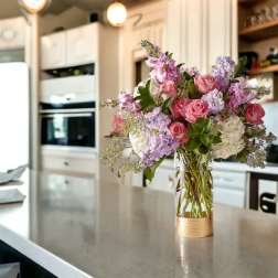Pink and lavender flower bouquet in a clear glass vase