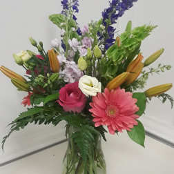 Mixed bouquet in a glass vase with pink gerbera daisies and lilies
