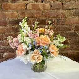 Peach and white floral arrangement in a clear glass vase