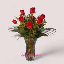 Red roses arranged in a clear glass vase