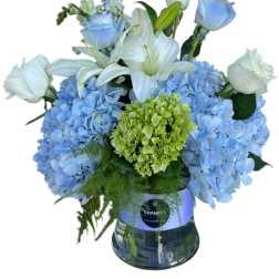 Blue hydrangeas and white lilies with roses in a glass vase