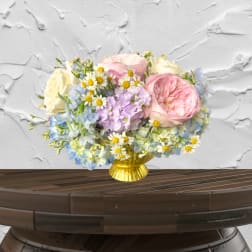 Pastel bouquet of roses, hydrangeas, and daisies in a gold vase