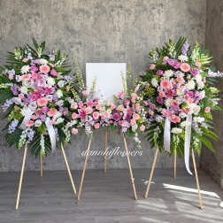 Three pastel floral standing sprays on easels with a blank center panel