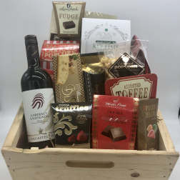 Gift basket with wine and assorted chocolates in a wooden crate
