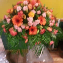 Large bouquet of orange and pink flowers with greenery