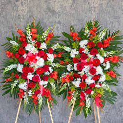 Two large standing floral sprays with red, white, and orange flowers