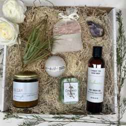 Gift box with roses, bath products, and a soap bar on shredded paper