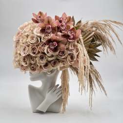 Blush rose and orchid arrangement on a mannequin bust with dried grasses