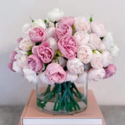 Pink and white roses arranged in a clear glass vase