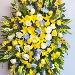 Large standing spray of yellow, white, and blue flowers