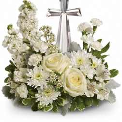White floral arrangement with roses, daisies, and a silver cross
