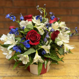 Red roses and white-blue alstroemeria in a wrapped vase arrangement