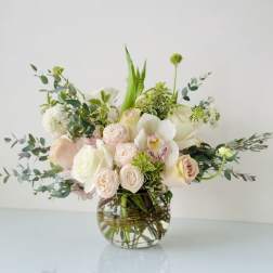 Blush and white floral arrangement in a clear glass vase