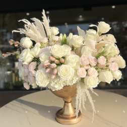 Cream and blush rose arrangement in a gold pedestal vase