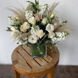 Cream and blush rose bouquet in a square glass vase