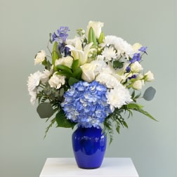 Blue and white floral arrangement in a cobalt vase