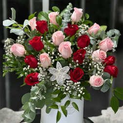 Bouquet of red and pink roses in a white box with a jeweled flower accent