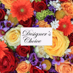 Mixed bouquet of roses, gerbera daisies, and purple blooms with a designer's choice card