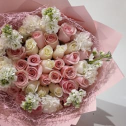 Bouquet of pink and white roses wrapped in pink paper