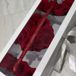 Red roses arranged in a white gift box with a ribbon