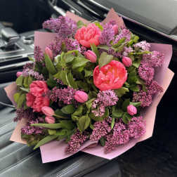Pink peonies and lilac blooms in pink wrapping