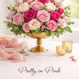 Pink and cream roses arranged in a gold pedestal vase
