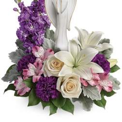 White angel figurine surrounded by purple and pink flowers