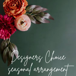 Floral arrangement with orange, pink, and magenta blooms on a dark green background