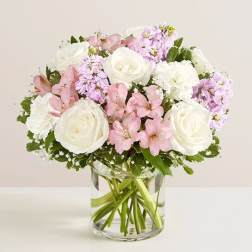Pink and white flowers arranged in a clear glass vase
