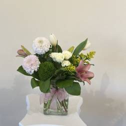 Mixed bouquet in a clear glass vase with pink lilies and white roses