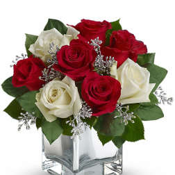 Red and white roses in a clear square vase