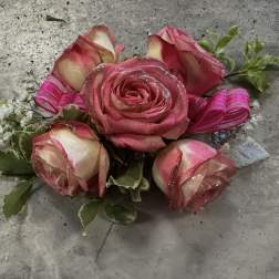 Pink roses with ribbon accents and variegated greenery