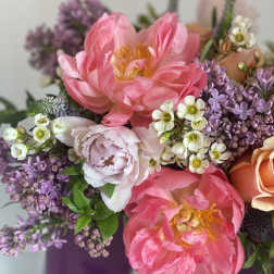 Pink peonies and purple lilacs in a vase