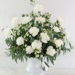 White flowers arranged in a white pedestal vase