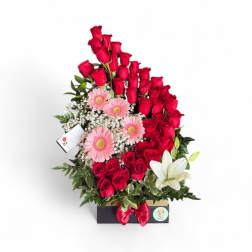 Red roses with pink gerberas and a white lily in a gift box