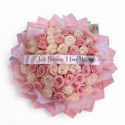 Bouquet of pink and cream roses wrapped in pink paper with a love-you ribbon