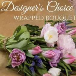 Wrapped bouquet of pink and white tulips with purple flowers