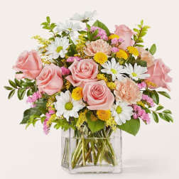 Pink roses and white daisies in a clear glass vase