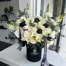 White rose bouquet in a black hatbox with a small teddy bear