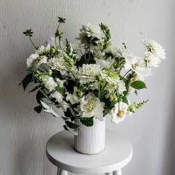 White flower arrangement in a ribbed white vase