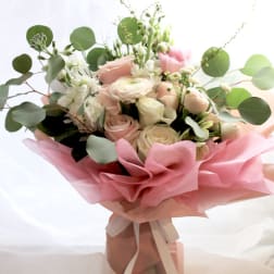 Pink and white rose bouquet with eucalyptus wrapped in pink paper