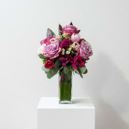 Always You ( Purple roses, deep pink anemones in a modern clear glass vase)