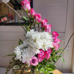 Pink roses and white daisies arranged in a glass vase