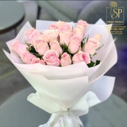 Bouquet of pale pink roses wrapped in white paper