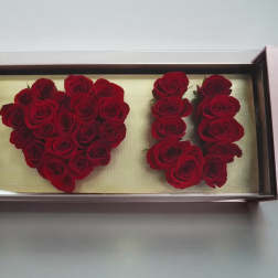 Red roses arranged in a rectangular display box spelling "I ♥ U"