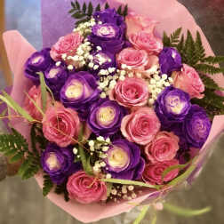Bouquet of pink and purple roses wrapped in pink paper