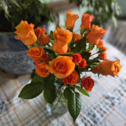 Orange roses arranged in a clear glass vase