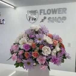 Pastel bouquet of daisies, roses, and carnations in a white box vase