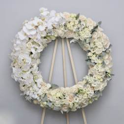 Large white floral wreath on a wooden easel