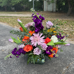 Mixed bouquet in a glass vase with purple, pink, orange, and white flowers